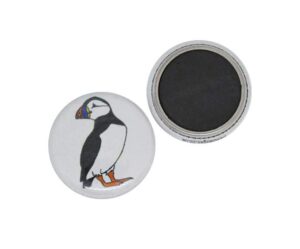 Two round magnets are shown; one displays an illustration of a puffin, while the other shows its plain black magnetic back.