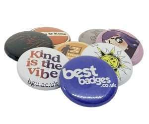 A set of seven 25mm button badges, each featuring unique designs and texts, displayed overlapping on a white background.