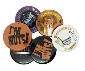 Six assorted 45mm Button Badges, including designs such as "I'M NUTS!", "Breakfast Monitor," and a cartoon squirrel labelled "CYRIL THE SQUIRREL.