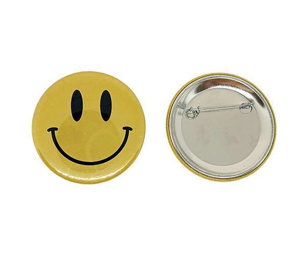 Two 58mm Button Badges are shown: one yellow and round with a black smiley face, and the other displaying its plain metal back with a pin fastening.