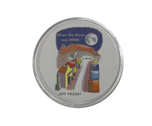 A round coaster featuring an illustration of a small town at night under a full moon, with the text "When the Moon was White" and "Jeff Probst" printed on it.