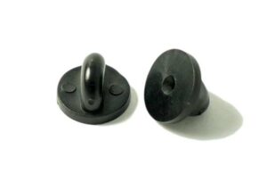 Two black plastic toggle buttons, one upright showing a central loop, the other lying flat displaying its hollow base, both on a white surface.