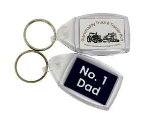 Two Acrylic Keyrings (35mm x 24mm): one displays the text "Glenamaddy Truck & Tractor Run" alongside an image of lorries, while the other features "No. 1 Dad" in white text on a navy background.