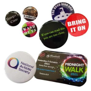 A collection of assorted badges displaying various designs, texts, and logos, including event information and organizational branding.