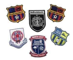 Six embroidered football club badges with various colors, crests, and text, including Chase Colts FC, Bedfordshire FA, Seahamed S.T.A.R. FC, North East Football Festival, and Longlands Lynx C.L.F.C.