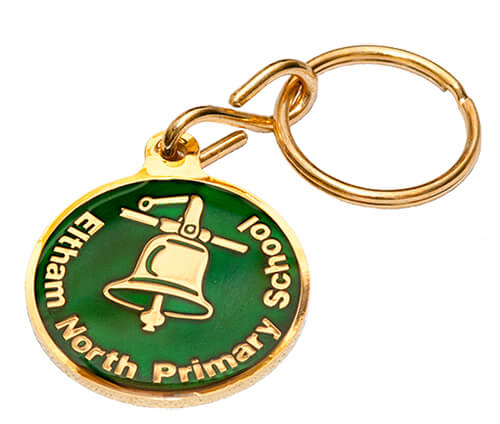 A round, gold and green keychain with a bell emblem and the text "Eltham North Primary School" around the edge.