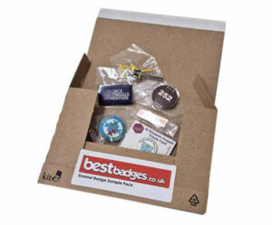 Enamel badge sample pack displayed in a small cardboard box with a red sticker showing the Best Badges website and the title of the pack; features various enamel badge designs and finishes