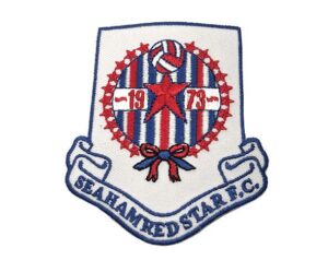 Embroidered badge of Seahanged Star F.C. featuring red, white, and blue stripes, a central star, a soccer ball, "1973" text, and a ribbon at the bottom.