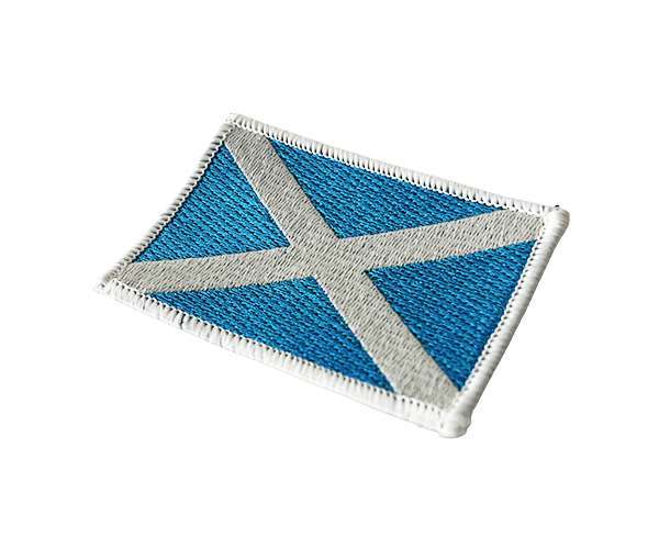 Scotland Flag Embroidered Badge showcasing a white diagonal cross on a blue background, displayed on a white surface.