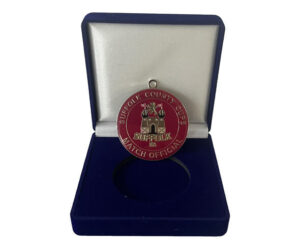 A Suffolk County Cups match official medal in a blue velvet display box with a white interior.
