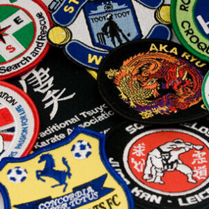 A selection of iron-on badges and patches featuring various designs and colors.