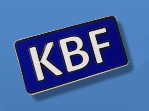 A rectangular blue sign with the white letters "KBF" in bold black outline on a plain blue background.