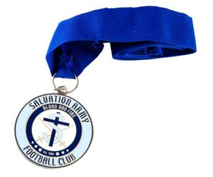 A round medal with a blue ribbon reads "Salvation Army Football Club" and "Blood and Fire," featuring a logo with a cross, sword, and anchor.