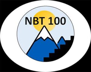 A circular logo showing a sun over a mountain with "NBT 100" text, alongside a stepped design, all enclosed in a white and black oval border.