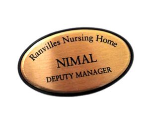 An oval name badge reads "Ranvilles Nursing Home, Nimal, Deputy Manager" in black text on a gold background.