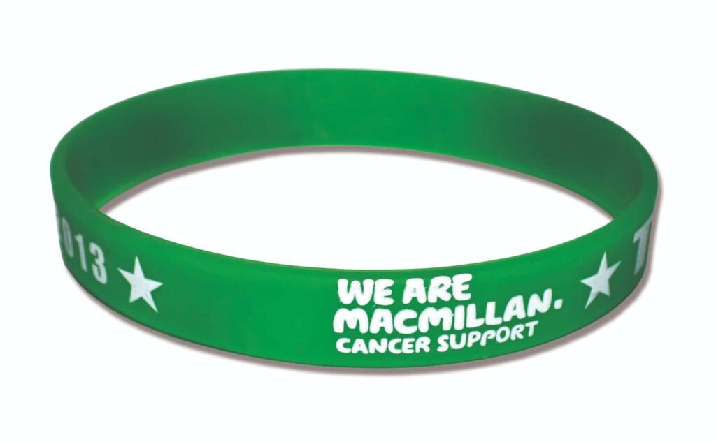 A green silicone wristband with white text that reads "We are Macmillan. Cancer Support" along with star symbols.
