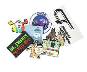 A selection of Soft PVC Fridge Magnets in various vibrant designs—featuring themes such as animals, cars, and events—is displayed scattered across a white background.