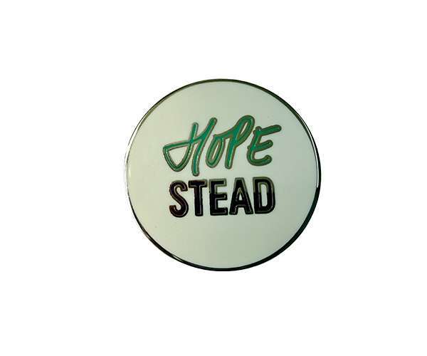 A Traditional Hard Enamel Badge featuring a round design with the word "HOPE" in green cursive above the word "STEAD" in black block letters on a white background.