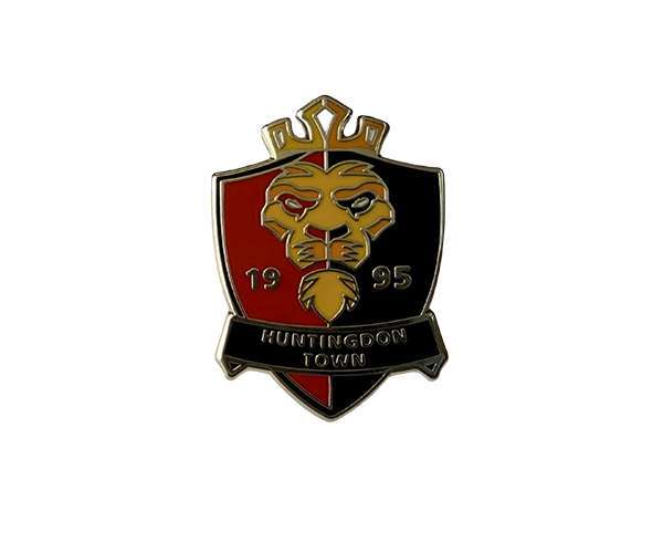 A Traditional Hard Enamel Badge features a lion's head, split red and black, with "1995" on the sides and "Huntingdon Town" on a banner below.