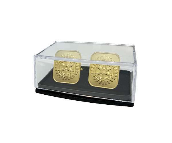 A pair of Rotary Gold Cufflinks featuring a square gear design, elegantly presented in a clear plastic case with a black base.