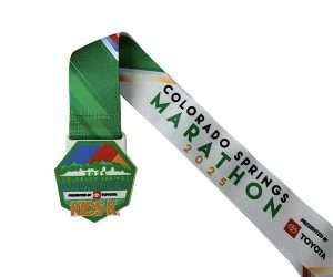 Soft PVC Medal with a green ribbon labelled "Colorado Springs Marathon 2025 KDSK," showcasing mountain imagery and donor logos, presented by Toyota. This vibrant Soft PVC Medal offers a modern twist on the traditional marathon keepsake.