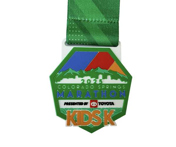 The 2025 Colorado Springs Marathon Soft PVC Medal, featuring a green ribbon, colourful mountain design, and "KIDS K" text.