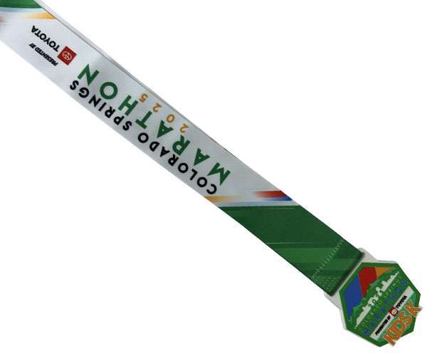 A Soft PVC Medal with a matching ribbon in green and white for the 2023 Colorado Springs Marathon, featuring event branding and sponsor logos.