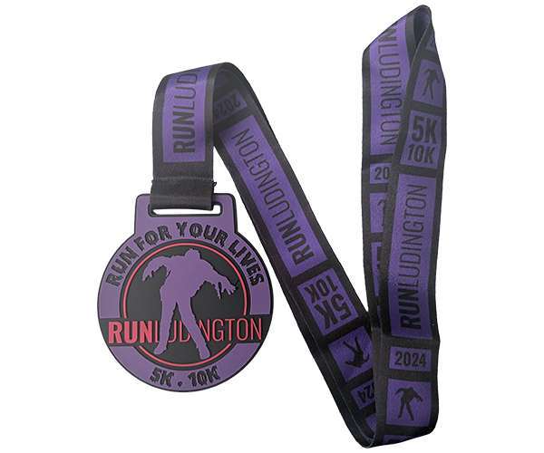 A Soft PVC Medal in purple and black, showcasing a bold "Run for Your Lives" zombie graphic, with "RUN LUDINGTON" and "5K 10K 2024" text featured on both the ribbon and the medal.