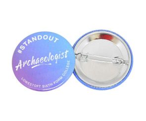 Two round pin badges, one showing the text "#STANDOUT Archaeologist LOWESTOFT SIXTH FORM COLLEGE" and the other showing the metal pin back.