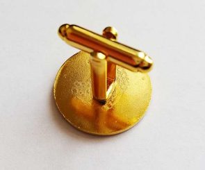 Gold-colored round cufflink photographed on a white background, showing the back side with the toggle bar in a vertical position.